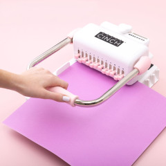 Hand bedient Cinch Bindewerkzeug zum Stanzen von Magenta-Cardstock in rosa-weißem Design