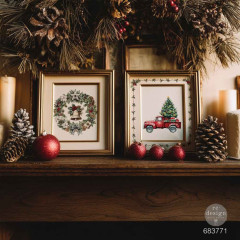 Zwei gerahmte Bilder mit Weihnachtsmotiven dekoriert auf einem Kamin mit Tannenzapfen und Kugeln