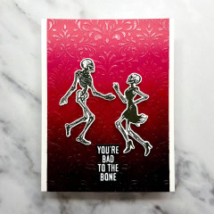 Karte mit tanzendem Skelettpaar vor Rot-Schwarz-Verlauf und Text You're bad to the bone