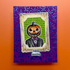 Halloween-Karte mit Kürbiskopf im Anzug in goldenem Rahmen auf Lila und Text happy haunting