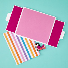 Fertig gestaltete Spellbinders Double Slider Karte in Rosa mit buntem gestreiftem Papier und Vogelmotiv