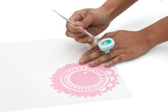 Hände beim Weeding: Ring-Sammler an Finger mit Weeding-Werkzeug über rosa Vinyl-Motiv