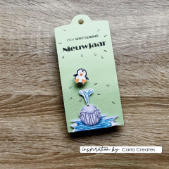 Grünes Geschenkanhänger-Tag mit gestempeltem Pinguin, Wal und Wasserfontäne auf Holzuntergrund