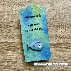 Selbstgemachter Geschenkanhänger mit blauem Aquarellhintergrund und gestempeltem Fisch-Motiv