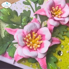 Nahaufnahme rosafarbener Akeleien-Blüten mit goldenen Staubgefäßen und glitzernden Blättern.