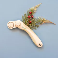 We R Memory Keepers Angled Rotary Cutter in Weiß neben Konifere und roten Beeren auf blauem Untergrund