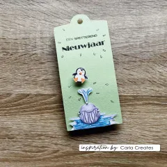 Grünes Geschenkanhänger-Tag mit gestempeltem Pinguin, Wal und Wasserfontäne auf Holzuntergrund