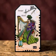 Anhänger-Karte im Briefmarken-Design mit der gestempelten Harfenspielerin und den Wörtern „Escape“, „Shine“ und „Play“.