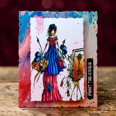 Kolorierte Beispielkarte mit der gestempelten Malerin-Figur auf zerrissenem Aquarell-Hintergrund und dem Schriftzug „PAINT THE WORLD“.
