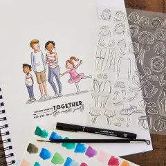 Anwendungsbeispiel: aquarellierte Familienszene neben Stempelbogen, Fineliner und Aquarellfarbpalette.