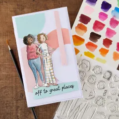 Anwendungsbeispiel: aquarellierte Kartengestaltung mit Frauenfiguren neben Stempelbogen und Aquarell-Farbpalette.