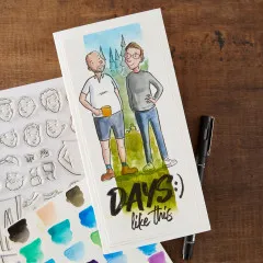Anwendungsbeispiel: aquarellierte Karte mit zwei Männerfiguren neben Stempelbogen, Fineliner und Aquarellfarben.