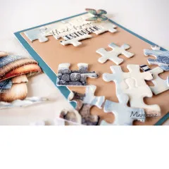 Nahaufnahme einzelner ausgestanzter Puzzleteile auf braunem Papier