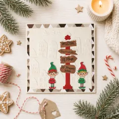 Weihnachtskarte mit gestanztem Wegweiser, Elfen und geprägtem Winterdorf, umgeben von Keksen und Zuckerstangen