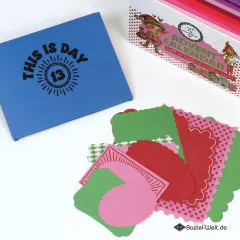 Detaillierte Ansicht des blauen Kärtchens Tag 13 neben herbstlich-weihnachtlichen Papier-Stanzteilen