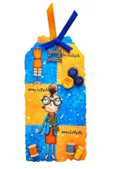 Blau-orangefarbenes Anhänge-Tag mit silbernem Nähmaschinen-Charm, Knöpfen und der Näh-Figur