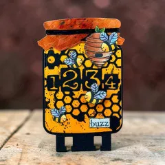 Honigglas-förmige Karte mit Bienen, Bienenstock und der Waben-Zahlen-Stanzform, Wortsticker „buzz"