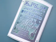 Nahaufnahme der Geburtstagskarte 'Dad Happy Birthday' mit funkelndem Farbverlauf und Sternendetails.