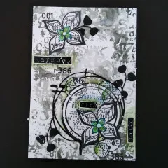 Schwarz-weiße Karte mit stilisiertem Blütenmotiv, der „t2"-Stanzform als Kreisrahmen und Wortstickern „Harmony", „Wish", „XOXO"