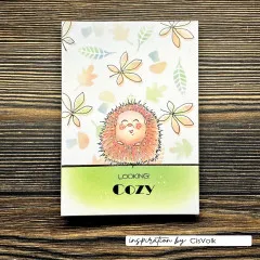 Karte mit pastellfarbenem Blätterhintergrund, koloriertem Igel-Stempelmotiv und Schriftzug 'Looking Cozy'