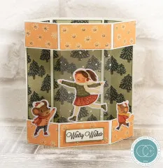 Sechseckige Laternenkarte mit Schlittschuhläuferin, Tannenmotiv und Schriftzug „Wintry Wishes“