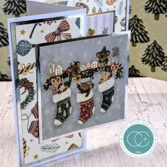 Sechseckige Laternenkarte mit Schlittschuhläuferin, Tannenmotiv und Schriftzug „Wintry Wishes“