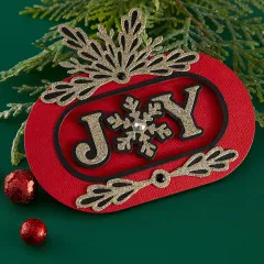 Weihnachtskarte mit goldfarbener und weißer geschichteter Schneeflocke sowie dem Schriftzug 'Snowflake Kisses' auf rosa Hintergrund.