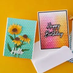 Zwei fertige Grußkarten: Hello-Karte mit den drei Sonnenhut-Blüten auf goldgepunktetem Türkis-Hintergrund und Happy-Birthday-Karte mit geprägtem Punktemuster im Pink-Orange-Farbverlauf