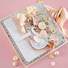 Detailaufnahme des fertigen Journal-Cover-Projekts mit dem gestalteten Schwan-Motiv, Bändern, Charm, Blüten und Knöpfen auf gemustertem Papier