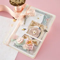 Detailaufnahme des fertigen Journal-Cover-Projekts mit gepresster/folierter Musterfläche, Schwan-Applikation, Scheren-Charm, Trockenblumen, Knöpfen und Perlenbordüre