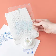 Grußkarte mit gestempelten Blüten-Motiven in Gelb und Rosa auf Papier, Rotating Press teilweise sichtbar, Korallengrund