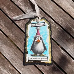 Koloriertes Anhänger-Tag mit gestempeltem Cheery Penguin Motiv und Spruch „All I want for Christmas is you".