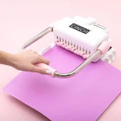 Hand bedient Cinch Bindewerkzeug zum Stanzen von Magenta-Cardstock in rosa-weißem Design