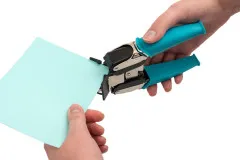 Corner Chomper wird von Hand verwendet zum Abrunden von Papierecken, türkise Silikongriffel sichtbar