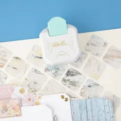 Eckenstanzer in türkis und weiß auf Scrapbooking-Papieren und Bastelmaterialien in Pastellfarben