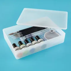 Offene Schale mit Pinseln, Sprühflaschen, Farbfläschchen und Glitzerpuder