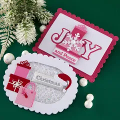 Detailaufnahme der Grußkarte 'Joy and Peace' mit gestapeltem Geschenk und Schneeflocken-Applikation.