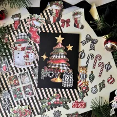 Ausgestanzte Weihnachts-Ephemera von Merry-ful Greetings auf schwarzem Untergrund: einzelne Stanzteile wie Kugeln, Zuckerstangen, Schleifen, Strümpfe und Ornamente