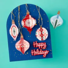 Weihnachtskarte mit aufgehängten Christbaumkugel-Stickern und Schriftzug „Happy Holidays“