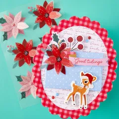 Weihnachtskarte mit rotem Weihnachtsstern-Sticker, Rehkitz-Motiv und Spruchband „Good tidings“