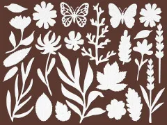 Ausgestanzte weiße Papierelemente: Blüten, Blätter, Schmetterlinge und Blütenzweige auf braunem Untergrund