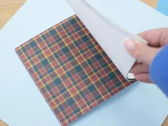 Aufgeschlagener Papierblock mit rot-grünem Karomuster im Vordergrund