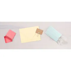 Selbstgemachte Papier-Box in rosa, gelb und türkis mit kleinem Umschlag