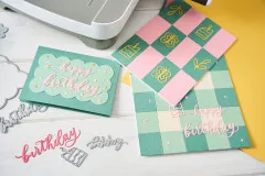 Grußkarten mit kariertem Hintergrundpapier und dem Schriftzug 'Happy Birthday' in unterschiedlichen Farbvarianten
