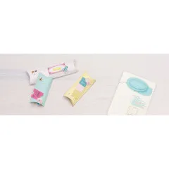 Drei fertig gestaltete Pillow Boxes in verschiedenen Farben und Designs auf Holztisch
