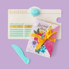 Mini Envelope Punch Board mit gestanztem Umschlag in Blümchen-Design, gelber Schleife auf violettem Hintergrund