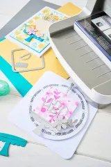 Nahaufnahme von Stanzformen, farbigem Cardstock und fertig gestalteten Geburtstagskarten