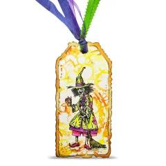 Gestaltetes Geschenketikett mit Clear Stamp Hexe, gelb-orange Hintergrund mit Ornamenten, Schleife