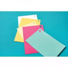 Gestapelte farbige Papiere in Weiß, Gelb, Creme, Pink und Aqua mit gestanzten Löchern auf türkisem Hintergrund