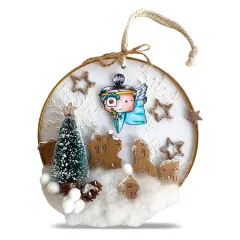Rundes Hänge-Ornament mit blau gekleideter Engelsfigur über einem Papphäuser-Winterdorf mit Mini-Tannenbaum.